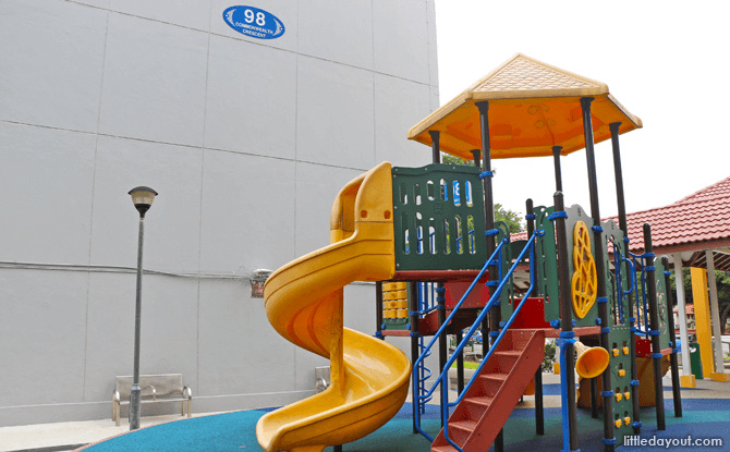 A colourful low play tower with orange slides beside Block 98 Commonwealth Crescent.