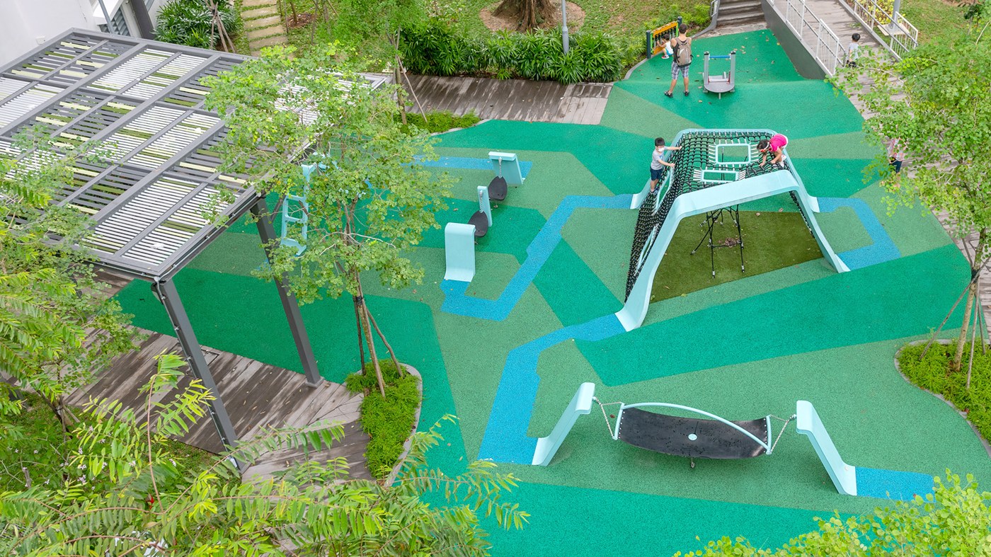 Pale-blue climbing frames, hammock seats and an embankment slide at Forfar Heights Block 53