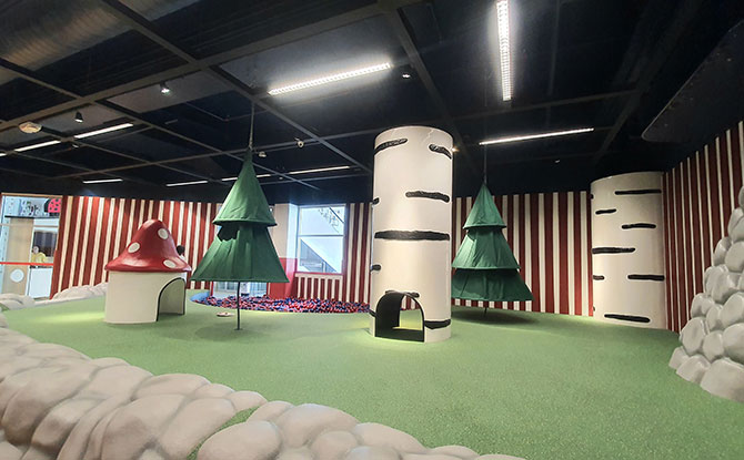 Forest-themed interior with birch-trunk columns and mushroom playhouse at IKEA Tampines Småland.