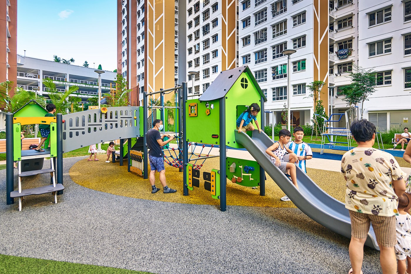 Green playhouses and low slides at the smaller Woodlands Glade playground.