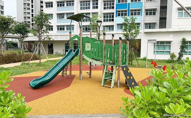Low green toddler slide and climbing platform beside Block 422B at Northshore StraitsView.