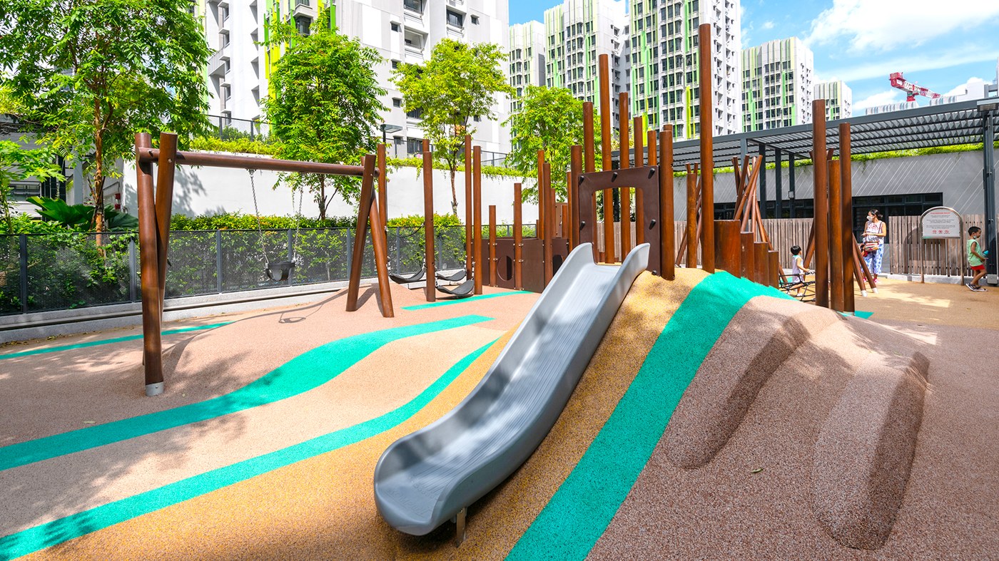 Brown forest posts, a mound slide and toddler swings at Alkaff Courtview's Level 4 Forest Playground
