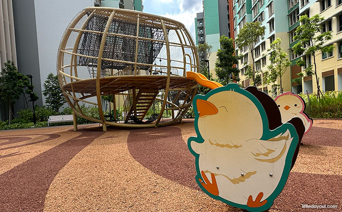 A netted chicken-nest play structure and chicken rocker at Hougang Olive.