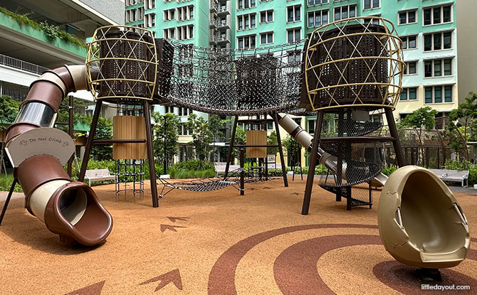 Elevated chicken-coop-themed climbing towers connected by rope bridges at Hougang Olive.
