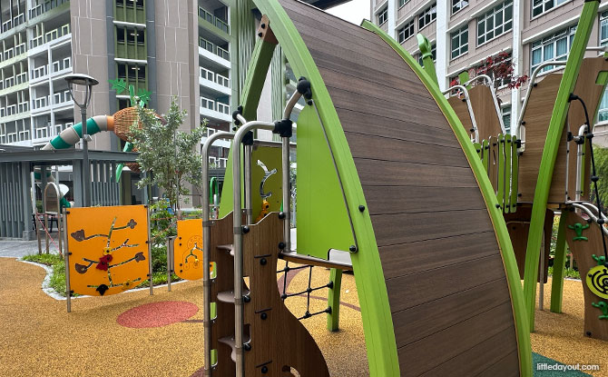 A low green mudskipper-themed climbing panel, straight slide and yellow play panels.