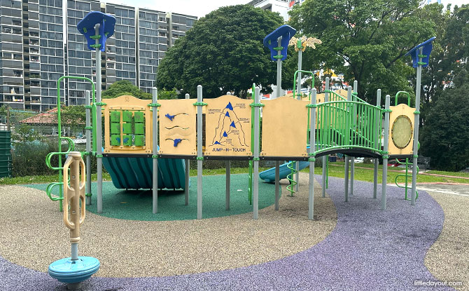 A low green and yellow play structure beside the Choa Chu Kang mini road safety park.