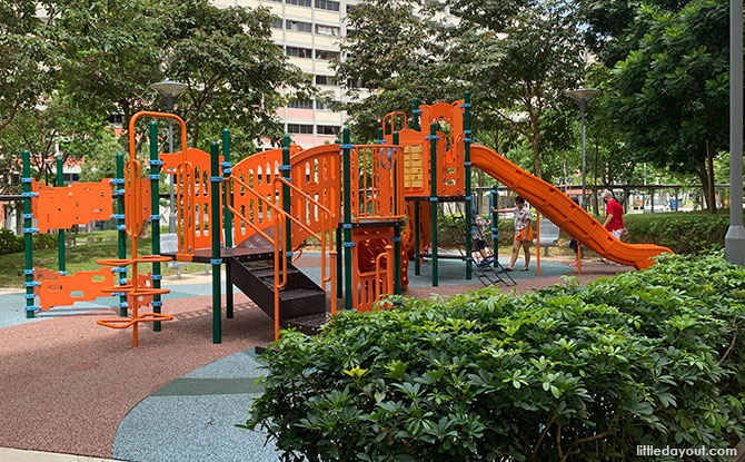 Low orange and black climbing frames and slides at the playground by Block 146.